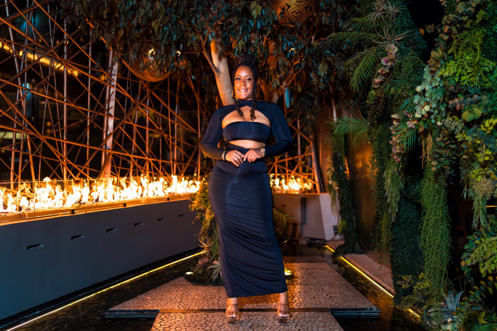 Las Vegas concert photoshoot — black gown beside the fire feature in the garden